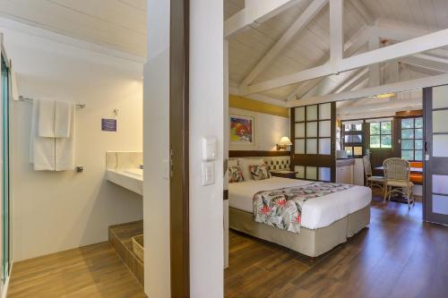 a bedroom with a bed and a bathroom at Costa Norte Ingleses Hotel in Florianópolis