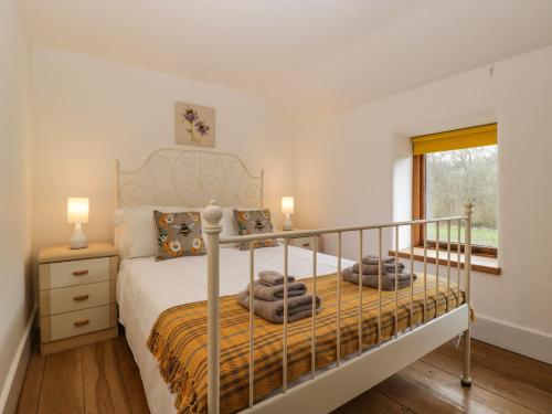 a bedroom with a bed with a metal bed frame at Beekeeper's Cottage in Leominster