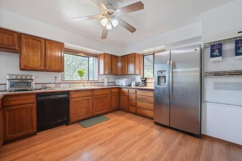 a kitchen with wooden cabinets and a stainless steel refrigerator at Mountain Home w/ a River in Back - Close to Skiing in Beaver