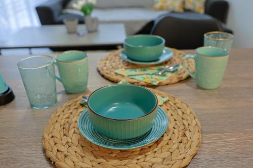 a table with two cups and plates on a table at Zeta-Garden Oasis & Private Parking by Optimum Link in Katerini