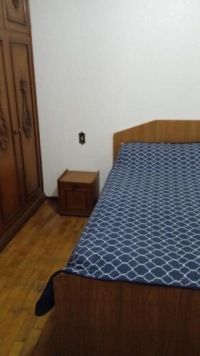 1 dormitorio con 1 cama y puerta de madera en Quarto superior com sacada. en Caxias do Sul