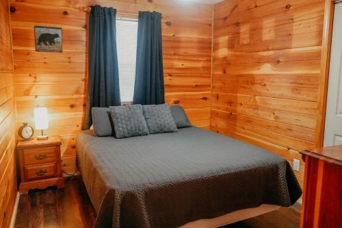 a bedroom with a bed in a room with wooden walls at Big Foot Bungalow in Sevierville