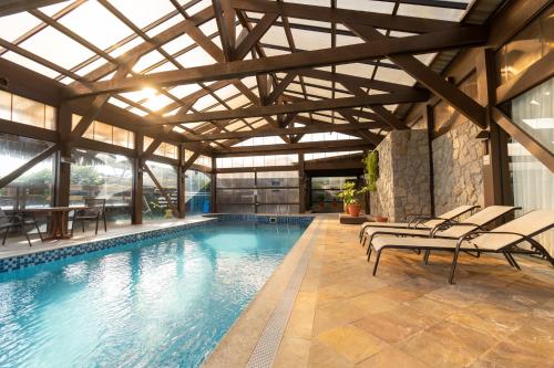 an indoor swimming pool with chairs and a building at Costa Norte Ingleses Hotel in Florianópolis