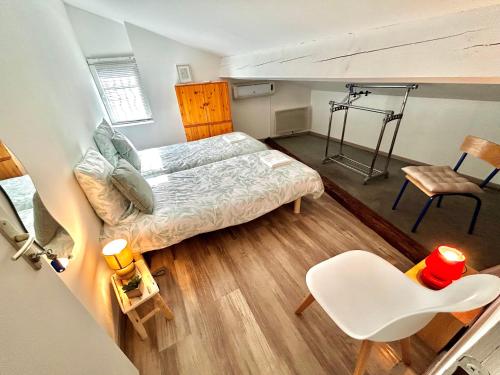 a small bedroom with a bed and a chair at Ô'Berge & Chambres Avignon in Avignon