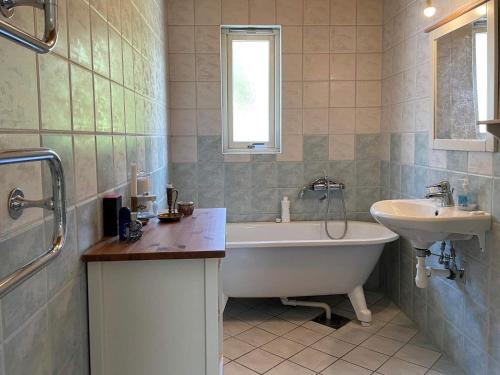 uma casa de banho com uma banheira e um lavatório e uma banheira em Holiday home MYGGENäS II em Myggenäs