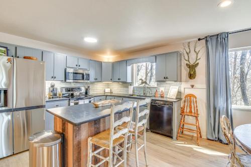 a kitchen with blue cabinets and a counter with stools at Classy Clayton Home with Views Less Than 1 Mi to Downtown! in Clayton