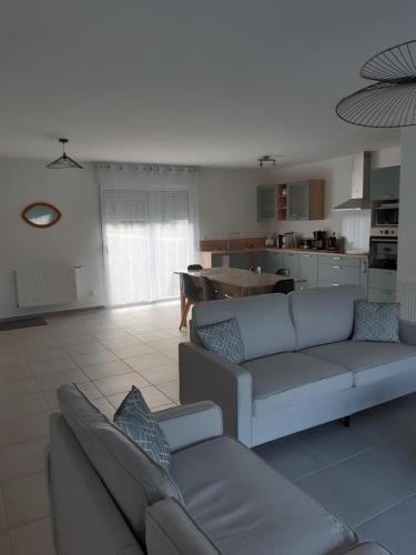 un salon avec deux canapés et une cuisine dans l'établissement Gîte neuf, à Dampierre-en-Burly