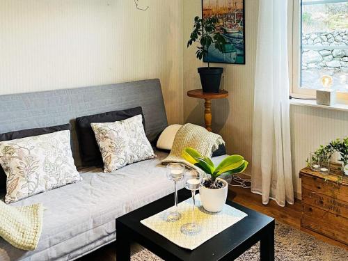 uma sala de estar com um sofá e uma mesa com copos de vinho em Holiday home STILLINGSÖN IV em Stillingsön