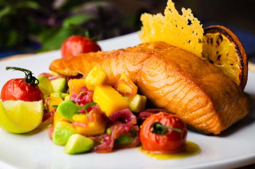 a plate of food with a fish and vegetables at Costa Norte Ingleses Hotel in Florianópolis