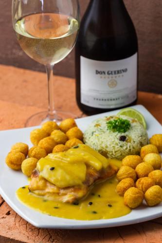 a plate of food with a bottle of wine and a glass at Costa Norte Ingleses Hotel in Florianópolis