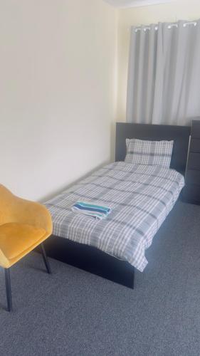 a bedroom with a bed and a chair in it at Budget Rooms in Fort William