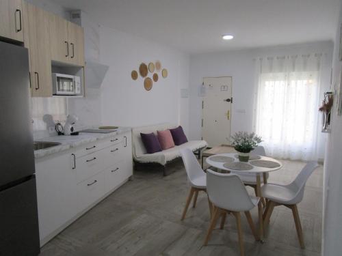 a kitchen with a table and chairs and a dining room at APARTAMENTO SOL in Chipiona