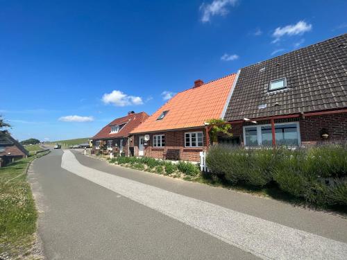 una fila de casas con techos rojos en una carretera en Dien to huus, en Nordstrand