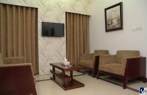 a waiting room with two chairs and a tv at Anchorage The Residence in Dhaka