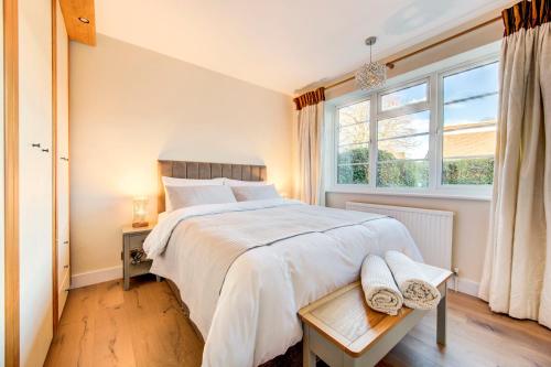 Bright Charming Apartment In Ealing في لندن: غرفة نوم بسرير كبير ونافذة