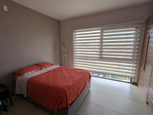 sypialnia z łóżkiem i oknem z żaluzjami w obiekcie Departamento Brittania Tower w mieście Guadalajara