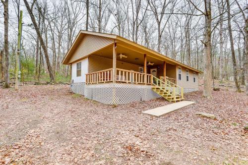 a small house with a porch in the woods at Heber Springs Cabin with Deck 3 Mi to Sugarloaf Mtn in Heber Springs