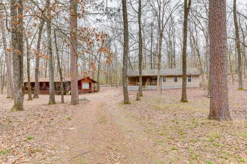 a house in the middle of a forest of trees at Heber Springs Cabin with Deck 3 Mi to Sugarloaf Mtn in Heber Springs
