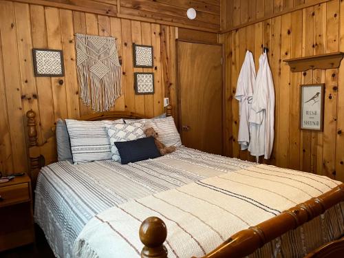 1 dormitorio con 1 cama en una pared de madera en Bryce’s Zion House by Bryce Canyon National Park!, en Panguitch