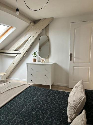 - une chambre avec un lit, un miroir et une commode dans l'établissement L appart', à Épernay