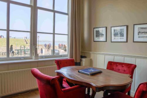 a dining room with a table and chairs and a window at Auberge de Campveerse Toren in Veere