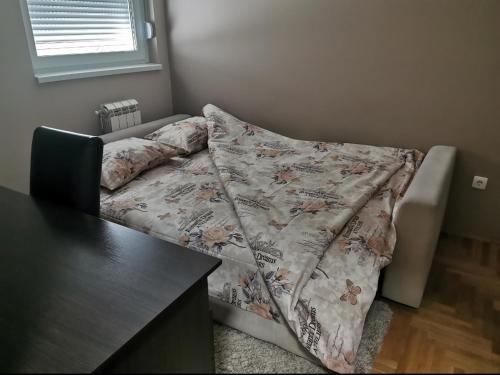 a bed with a blanket on it in a room at Mint in Sremska Mitrovica