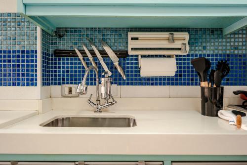 um balcão de cozinha com um lavatório com utensílios em AP NA BELA VISTA, PRÓXIMO AO BEXIGA, STUDIO PRIVATIVO E COMPLETO em São Paulo