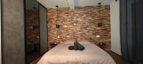 une chambre avec un lit avec un mur de briques dans l'établissement Maison Familiale proche Disney, à Condé-Sainte-Libiaire