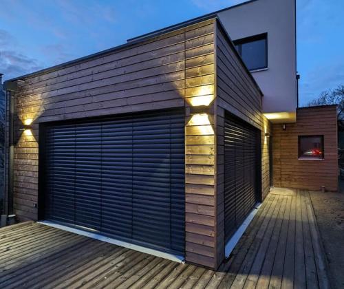 un bâtiment avec deux portes de garage sur une terrasse dans l'établissement Maison Familiale proche Disney, à Condé-Sainte-Libiaire