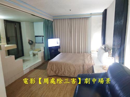 a hotel room with a bed and a television at Modern Plaza Hotel in Kaohsiung