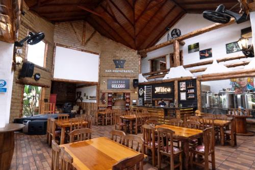 ein leeres Restaurant mit Holztischen und -stühlen in der Unterkunft EL DESCANSO DEL TORO HOSTERIA-SPA in Vilcabamba
