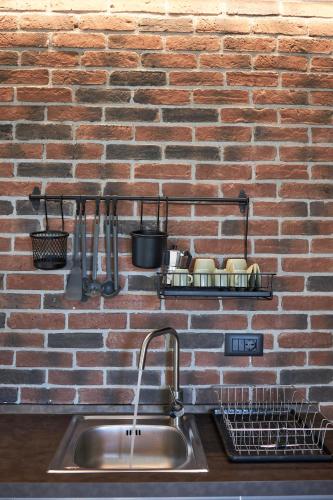 a kitchen counter with a sink and a brick wall at Plebiscito Old Fashion in Castel di Sangro