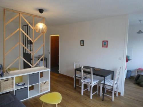 un salon avec une table et des chaises de salle à manger dans l'établissement Appartement calme et cosy, à Caen