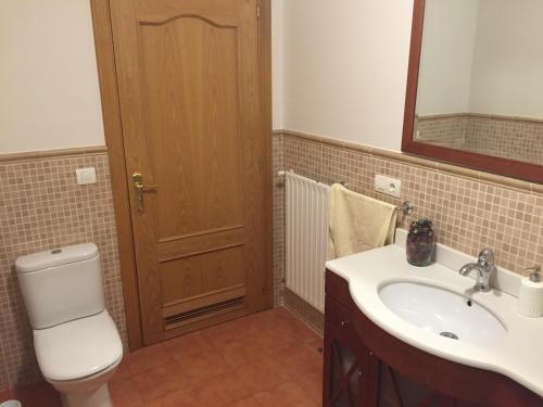 uma casa de banho com um WC, um lavatório e um espelho. em Apartamento Costa con Parking Privado Incluido em Zumaia