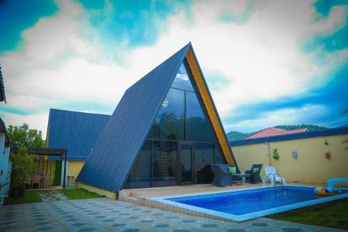 a house with a swimming pool with a pyramid shaped roof at Gabala Twin A Frame Villas in Gabala
