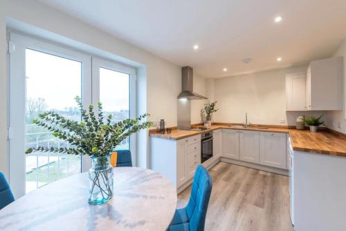 a kitchen with a table with a vase of flowers on it at *Penthouse Luxury Apartment 2min to City in Carlisle