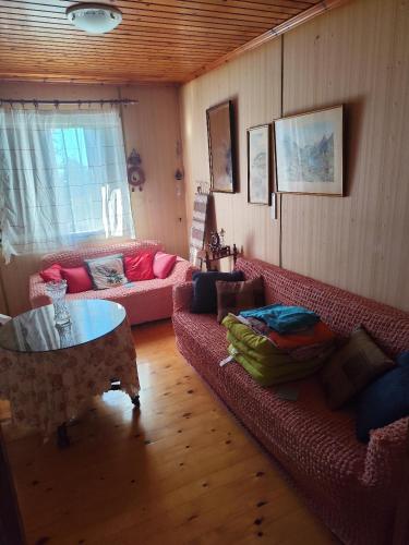 a living room with two couches and a table at σπίτι - αγρόκτημα - Δ Γεωργά Χατζηράση οδός Χατζηράση in Porto Heli