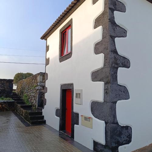 a building with a staircase next to a red door at Casa do Poço in Santa Bárbara