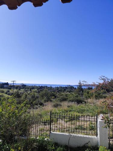 a fence with a view of a field at σπίτι - αγρόκτημα - Δ Γεωργά Χατζηράση οδός Χατζηράση in Porto Heli