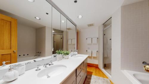 a bathroom with two sinks and a large mirror at Woodrun Place in Snowmass Village