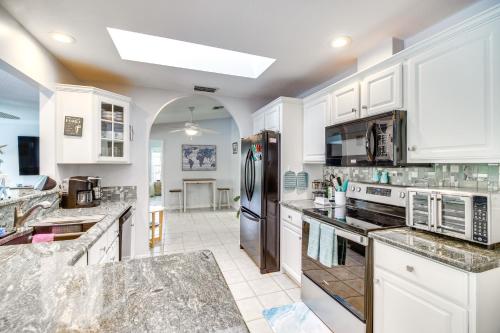 a kitchen with white cabinets and stainless steel appliances at Sebastien Home with Pool and Gazebo - 8 Mi to Beaches! in Sebastian