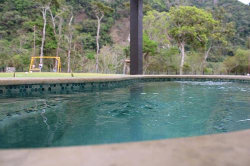 una piscina de agua con un parque infantil al fondo en Cabañas La Encantada, en Aroma