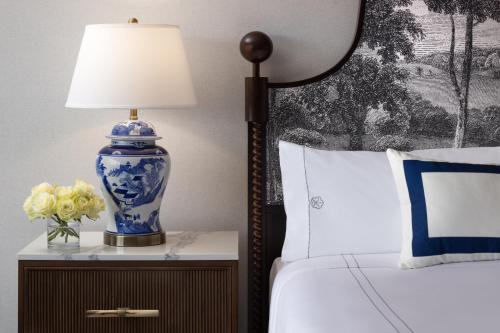 a blue and white lamp on a night stand next to a bed at Omni Charlottesville Hotel in Charlottesville
