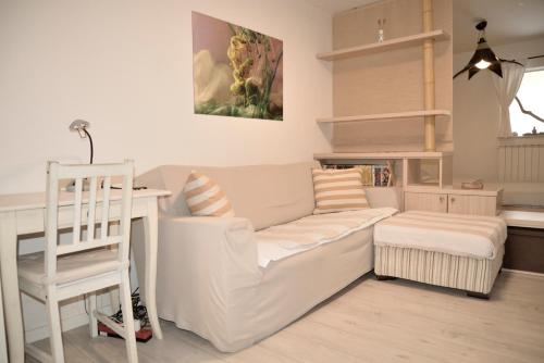 sala de estar con sofá blanco y escritorio en Medizen Apartment en Izola
