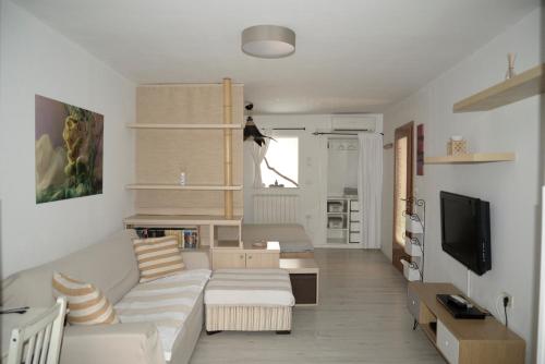 a living room with a white couch and a tv at Medizen Apartment in Izola