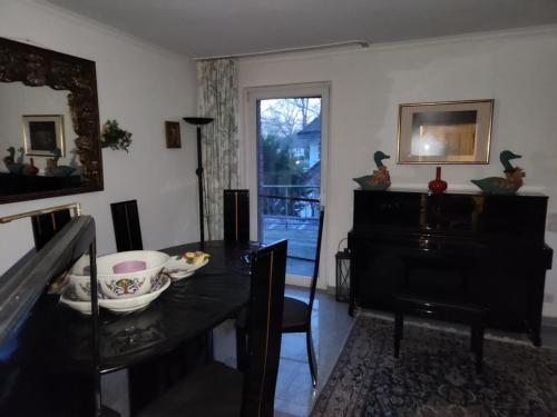 a dining room with a table and a piano at villa high ceiling 2 bedrooms in Troisdorf
