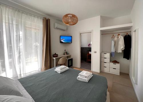 1 dormitorio con 1 cama con 2 toallas en Casa Cunaci Bed and Breakfast, en Capo Vaticano
