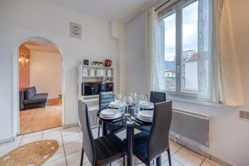 une salle à manger avec une table et des chaises et une fenêtre dans l'établissement Le Guynemer - Rocade / Tram, à Grenoble