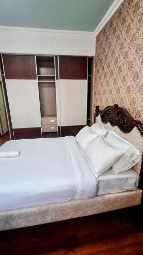 1 dormitorio con 1 cama grande con almohadas blancas en Executive two bedrooms, en Nairobi