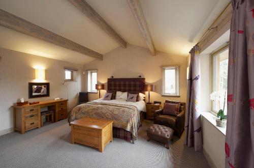 1 dormitorio con cama, escritorio y silla en Ness Castle Lodges, en Inverness